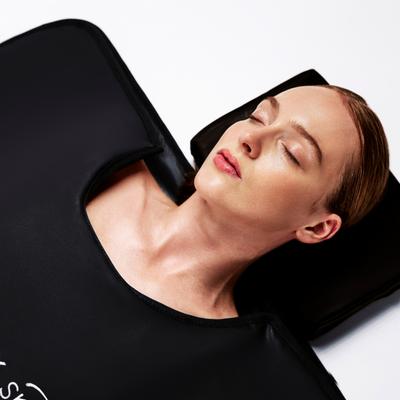 Woman lying in currentbody sauna blanket close up